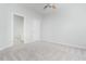 Spacious bedroom featuring ceiling fan, neutral carpet, and en-suite bathroom access at 3601 Sugar Tree Pl, Durham, NC 27713