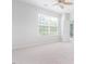 Bright, carpeted bedroom with ceiling fan, large window, and backyard access at 3601 Sugar Tree Pl, Durham, NC 27713