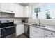 Bright kitchen with modern appliances, stainless steel sink, and tiled backsplash at 3601 Sugar Tree Pl, Durham, NC 27713