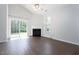 Bright living room with fireplace, wood floors, ceiling fan, and sliding glass door to backyard at 3601 Sugar Tree Pl, Durham, NC 27713