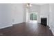 Bright living room with fireplace, wood floors, and sliding glass door to backyard at 3601 Sugar Tree Pl, Durham, NC 27713