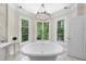 Luxurious bathroom with natural light featuring a soaking tub, marble floors, and scenic views at 3617 Carlow Ct, Raleigh, NC 27612