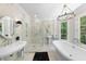 Bright bathroom features soaking tub, glass enclosed shower, and dual sinks with marble counters and tiled walls at 3617 Carlow Ct, Raleigh, NC 27612