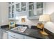 Elegant wet bar with granite countertop, stainless sink, attractive display cabinets and decorative accents at 3617 Carlow Ct, Raleigh, NC 27612