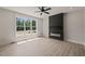 Bright living room with sleek black fireplace and large window showcasing a serene wooded view at 380 Pilot Ridge Rd, Zebulon, NC 27597