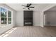 Bright living room featuring a large window, modern black fireplace, and wood-look floors at 380 Pilot Ridge Rd, Zebulon, NC 27597
