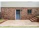 Exterior view of the brick back of the house, featuring a door with window and brick stairs at 4006 Daniel Rd, Durham, NC 27703