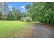 Inviting home surrounded by a lush green lawn and mature trees, featuring a charming brick and siding exterior at 4006 Daniel Rd, Durham, NC 27703
