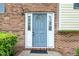 Close-up of the front door, showing the brick facade and decorative sidelights, with a gray painted door at 4006 Daniel Rd, Durham, NC 27703