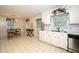 Bright eat-in kitchen featuring white cabinetry, stainless steel appliances, and decorative floral accents at 4006 Daniel Rd, Durham, NC 27703