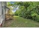 Lush backyard featuring a wooden porch and an expansive green lawn with mature trees, offering privacy at 407 Collier St, Smithfield, NC 27577