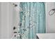 Clean bathroom features a shower with a decorative curtain, dark hardware, and soft, natural lighting at 407 Collier St, Smithfield, NC 27577