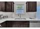 Close-up of sink, quartz countertops, and dark wood cabinets in a modern kitchen with window view at 407 Collier St, Smithfield, NC 27577