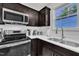 Close-up of stainless steel appliances, quartz countertops, sink, and dark wood cabinets in kitchen at 407 Collier St, Smithfield, NC 27577