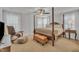 Bright main bedroom features a four poster bed, ceiling fan, and an upholstered sitting area at 407 Collier St, Smithfield, NC 27577