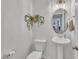 A stylish powder room featuring pedestal sink, toilet and decorative wall art at 407 Collier St, Smithfield, NC 27577