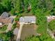 Stunning aerial view of a bright, white two-story home nestled among mature trees with a long driveway at 4109 Huckleberry Dr, Raleigh, NC 27612