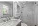 Bathroom featuring a glass shower, large mirror, and white tiling around the shower and in the background at 4109 Huckleberry Dr, Raleigh, NC 27612