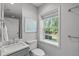 Bright bathroom with a modern vanity, ample natural light, and a window view of the backyard at 4109 Huckleberry Dr, Raleigh, NC 27612