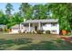 Charming white brick home with grey shutters, manicured lawn, and an American flag displayed at 4109 Huckleberry Dr, Raleigh, NC 27612