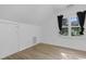 Bedroom with wood-look flooring and a window with black curtains at 413 Redpath Dr, Garner, NC 27529