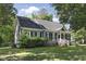 Landscaped front yard of a gray home with white trim, black shutters and a black roof at 413 Redpath Dr, Garner, NC 27529