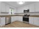 Bright kitchen with stainless steel appliances, laminate floors and light colored counter tops at 413 Redpath Dr, Garner, NC 27529