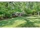 Well-maintained front yard featuring lush lawn, mature trees, and landscaped garden beds at 415 Forsyth St, Raleigh, NC 27609