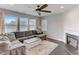 Cozy living room with a fireplace, ceiling fan, and large windows for natural light at 4613 Jersey Pine Dr, Rolesville, NC 27571