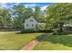 Inviting home exterior with a stone path leading to the house and lush landscaping at 4900 North Hills Dr, Raleigh, NC 27612