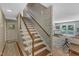 Staircase with wood treads and white risers that leads to a living area with glass doors at 4900 North Hills Dr, Raleigh, NC 27612