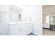 Bright bathroom featuring double vanity with white cabinets and a view into the bedroom at 493 Lochalsh Dr, Gibsonville, NC 27249