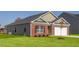 Side view of brick home featuring a well-manicured lawn and attached garage at 493 Lochalsh Dr, Gibsonville, NC 27249