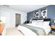 Comfortable main bedroom with accent wall, soft lighting, and adjacent main bathroom at 493 Lochalsh Dr, Gibsonville, NC 27249