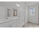 Well-lit bathroom featuring dual sinks, tile floors, and a large mirror at 5054 Kota St, Raleigh, NC 27610