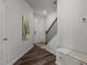Inviting entryway featuring wood-look floors, staircase, and convenient storage bench at 5054 Kota St, Raleigh, NC 27610
