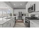 Bright kitchen with stainless steel appliances, quartz countertops, and modern subway tile backsplash at 5054 Kota St, Raleigh, NC 27610