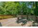 Wooden deck in the backyard with a fire pit, surrounded by greenery at 5100 Yale Ct, Graham, NC 27253