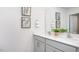 Double sink vanity with quartz countertop, framed botanical art, and large mirror at 511 Lochalsh Dr, Gibsonville, NC 27249