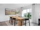 Dining area features a rustic wood table, modern seating, and sliding glass door to backyard at 511 Lochalsh Dr, Gibsonville, NC 27249
