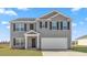 Two story home with gray siding, a two-car garage and a well-manicured lawn at 511 Lochalsh Dr, Gibsonville, NC 27249