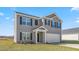 Two-story home with gray exterior, a two-car garage and a green lawn at 511 Lochalsh Dr, Gibsonville, NC 27249