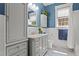 Bright, spacious bathroom features a vanity with drawers, a mirror, and stylish blue and white tiled floors at 518 S Main St, Wake Forest, NC 27587
