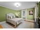 Serene bedroom features a bed, patterned rug, accent lighting, artwork and natural light from the window at 518 S Main St, Wake Forest, NC 27587