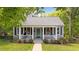 Charming front exterior of home with mature trees, porch, sidewalk and beautiful flower boxes and landscaping at 518 S Main St, Wake Forest, NC 27587
