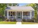 Charming home featuring a welcoming front porch with hanging plants and a well-maintained landscaped yard at 518 S Main St, Wake Forest, NC 27587