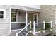 View of a charming front porch with flowers and neutral colored siding at 518 S Main St, Wake Forest, NC 27587