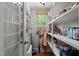 Well-organized pantry featuring storage shelves, window with natural light, and cleaning supply storage at 518 S Main St, Wake Forest, NC 27587