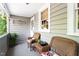 Charming porch with wicker chairs, a small accent table, potted plants, and soft exterior lighting at 518 S Main St, Wake Forest, NC 27587