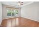 Empty bedroom features hardwood floors, a modern ceiling fan and a bright window for ample natural light at 519 Garendon Dr, Cary, NC 27519